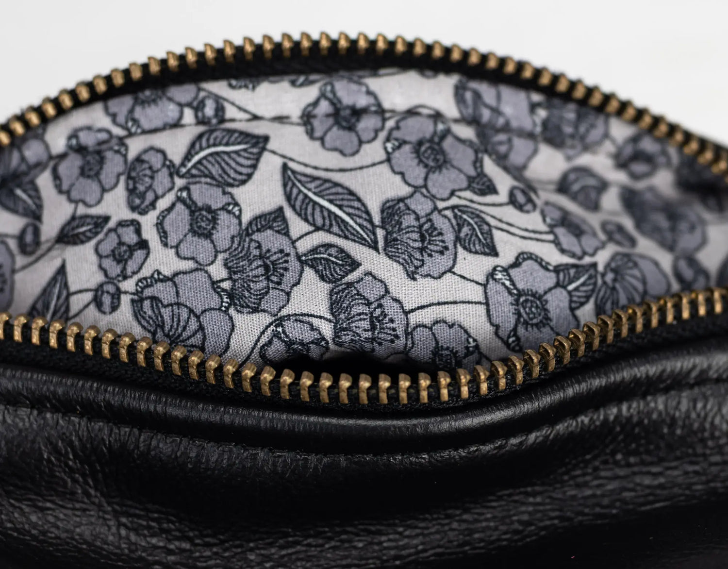 Close-up of a black leather pouch with a floral patterned interior.