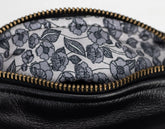 Close-up of a black leather pouch with a floral patterned interior.