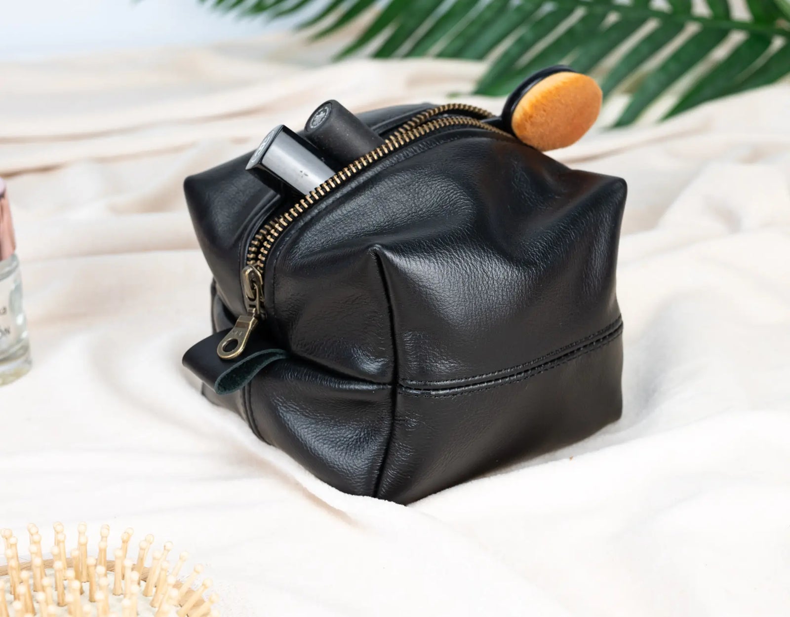 Black leather pouch with a zipper on a light background#color_black
