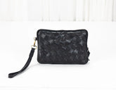 Black woven handbag on a white background