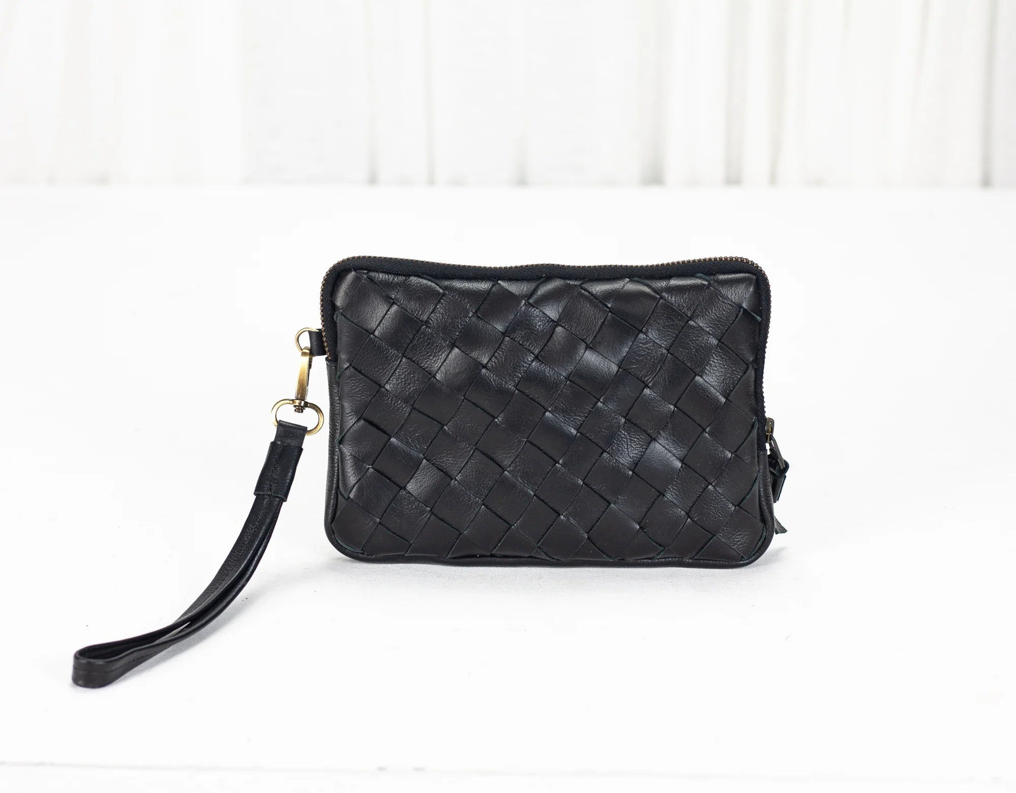 Black woven handbag on a white background