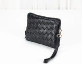 Black woven clutch bag on a white background