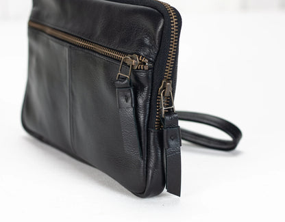 Black leather bag with gold zipper on a white background