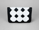 Black and white geometric patterned clutch bag on a gray background