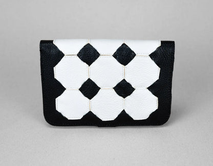Black and white geometric patterned clutch bag on a gray background