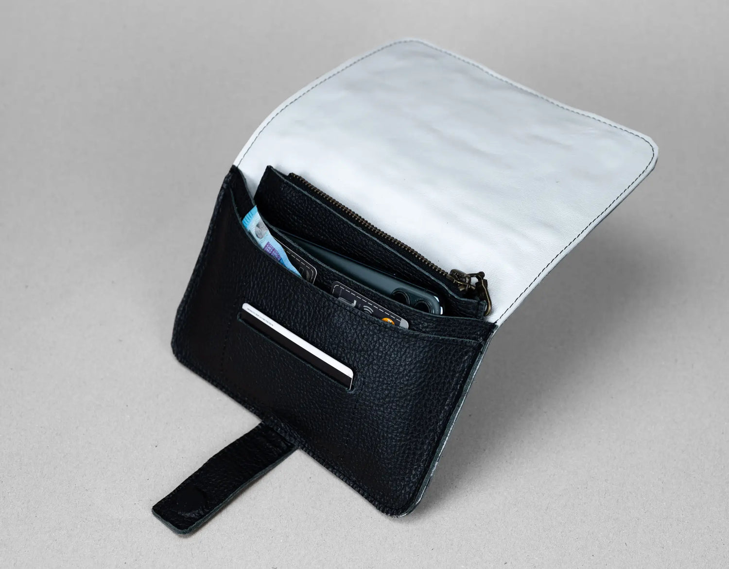 Black leather wallet with a white interior on a gray background