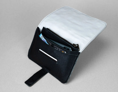 Black leather wallet with a white interior on a gray background