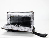 Floral-patterned clutch bag with a black interior on a white background