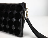 Black quilted clutch bag with a strap on a white background