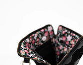 Floral-patterned clutch bag with a black interior on a white background