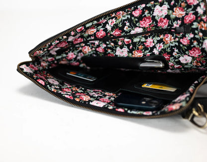 Floral patterned wallet with phone inside on a white background