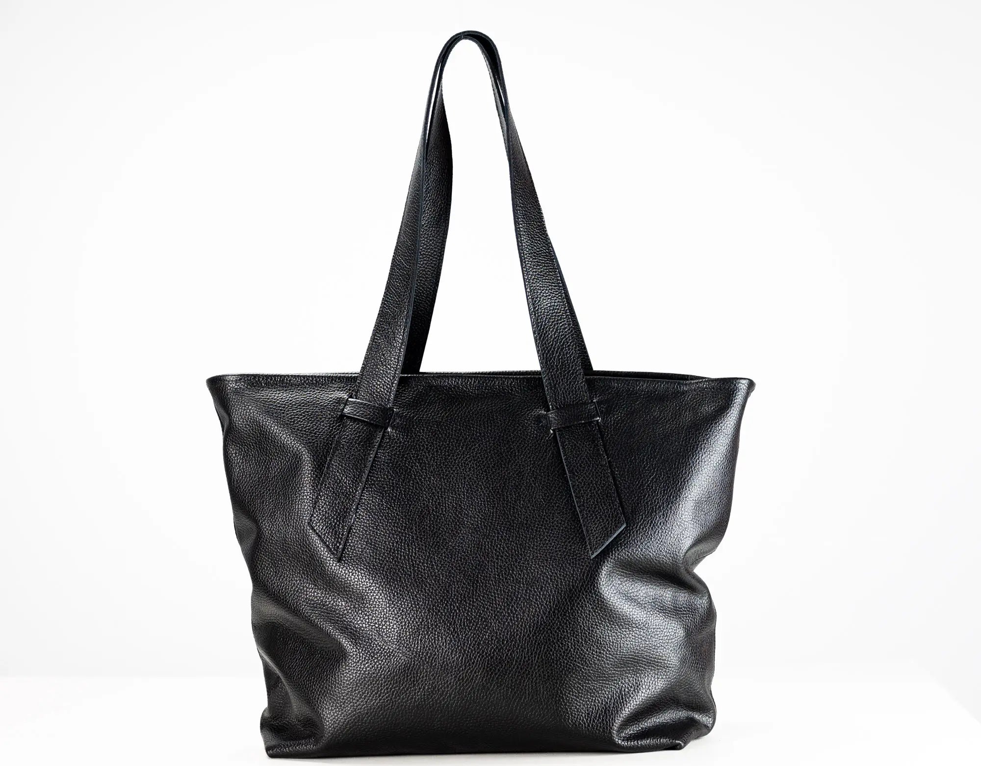A black pebbled leather tote bag with two shoulder straps, photographed against a clean white background.