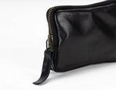 Black leather pouch with zipper on a white background