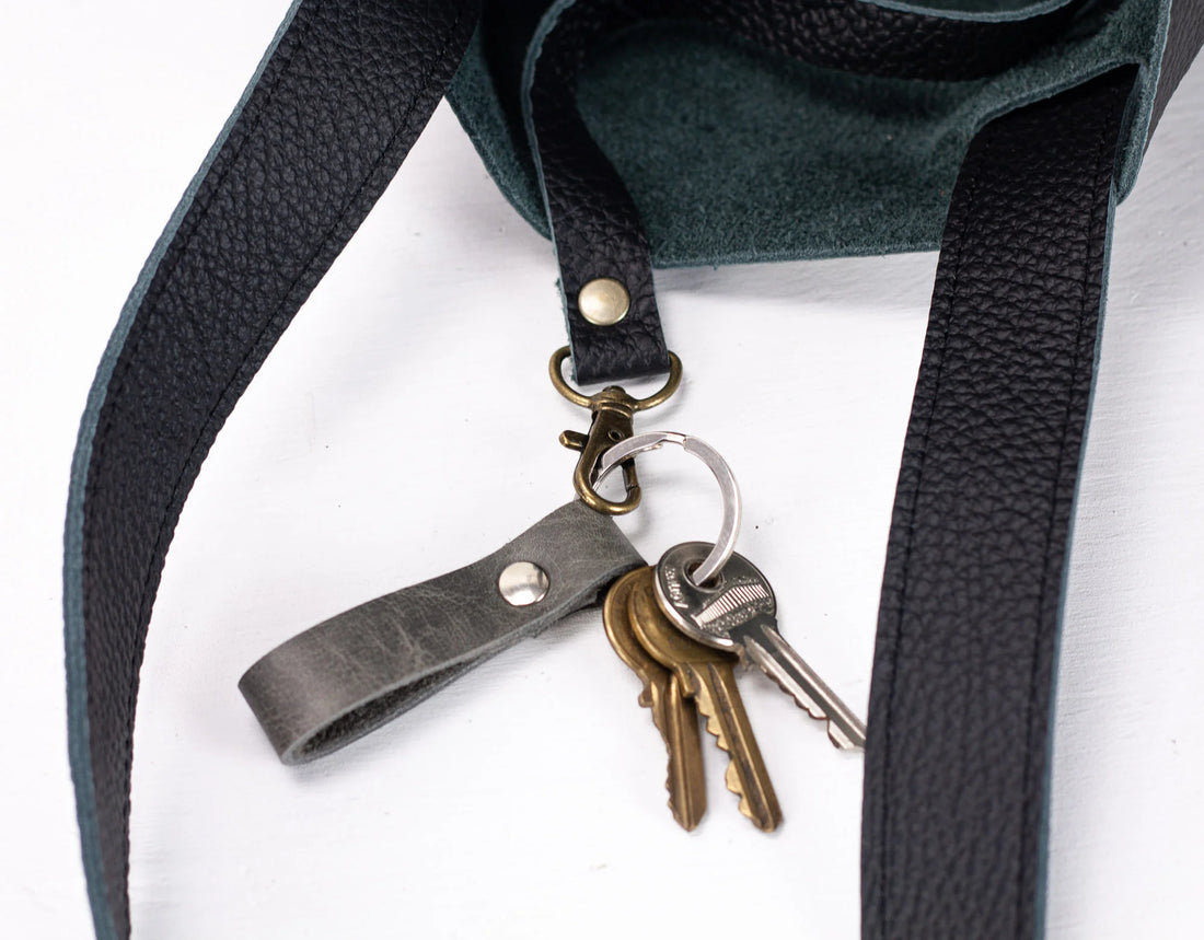 Keychain with keys attached to a dark green bag strap