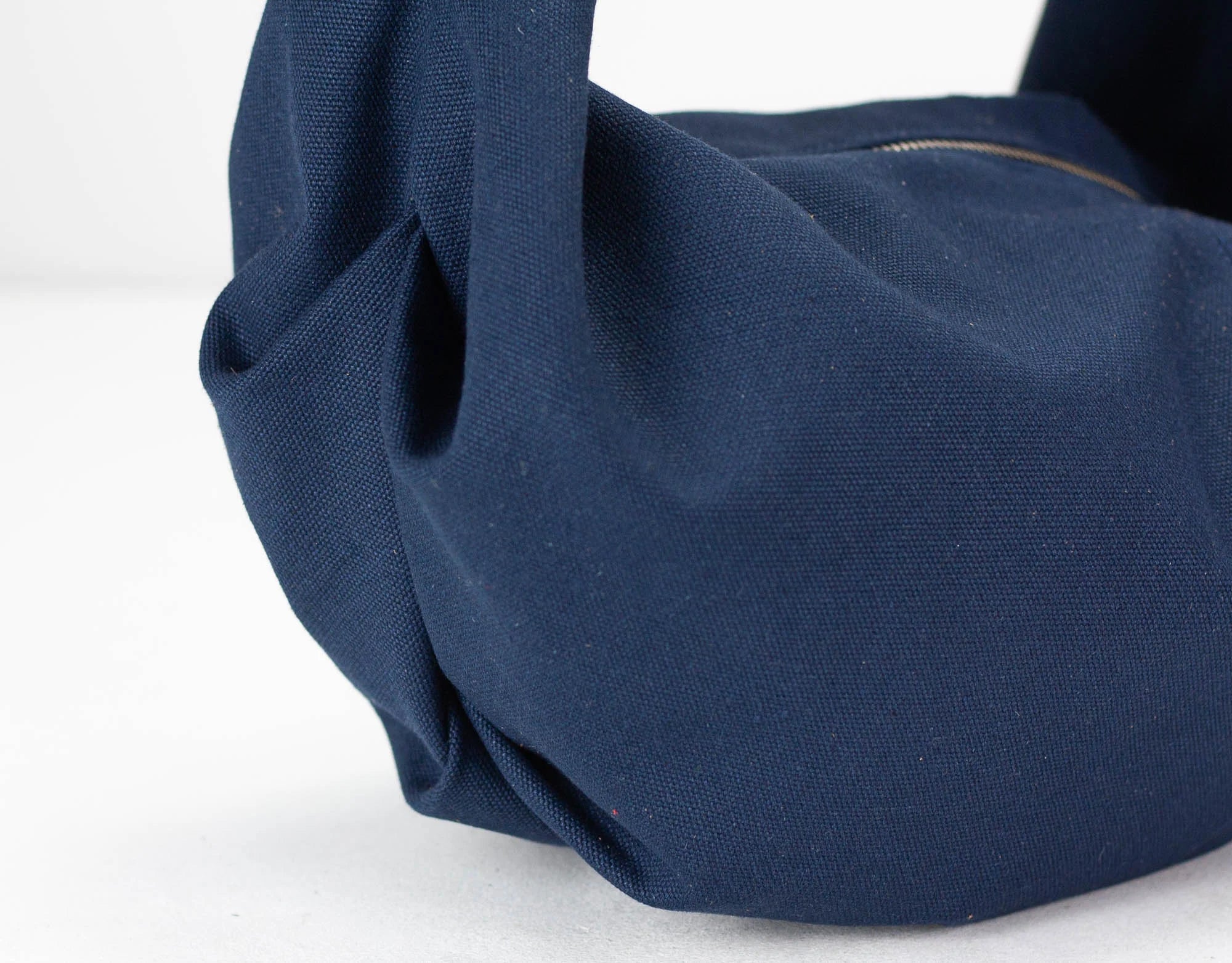 Close-up of a navy blue bag on a white background