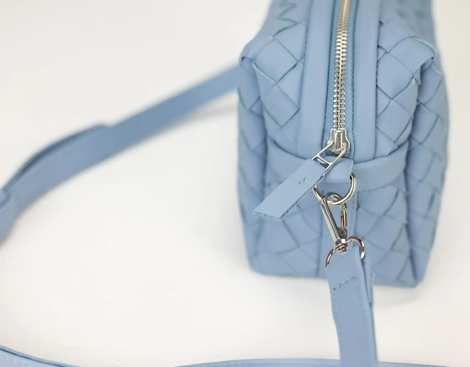 Light blue handbag with a zipper on a white background