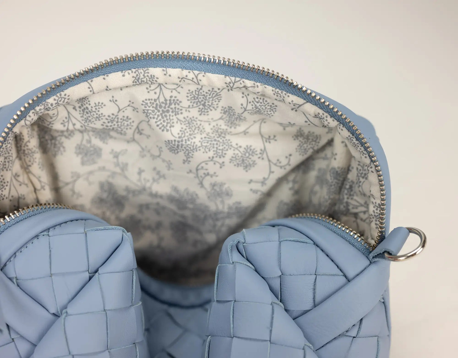 Close-up of a blue woven handbag with floral lining