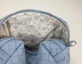 Close-up of a blue woven handbag with floral lining