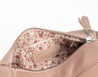 Close-up of a beige handbag with floral interior pocket on a white background