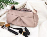 Makeup bag with brushes and lipsticks on a light background