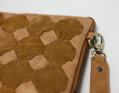 Brown leather clutch with geometric pattern on a white background