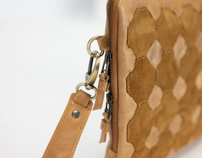 Close-up of a brown leather bag with geometric pattern on a white background