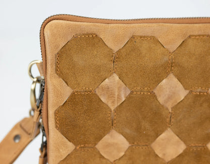 Brown leather clutch with geometric pattern on a light gray background