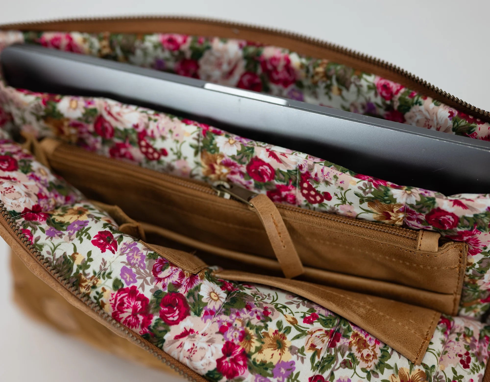 Floral-patterned case with a brown zipper on a white background