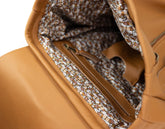 Close-up of a brown leather bag with a textured interior lining.