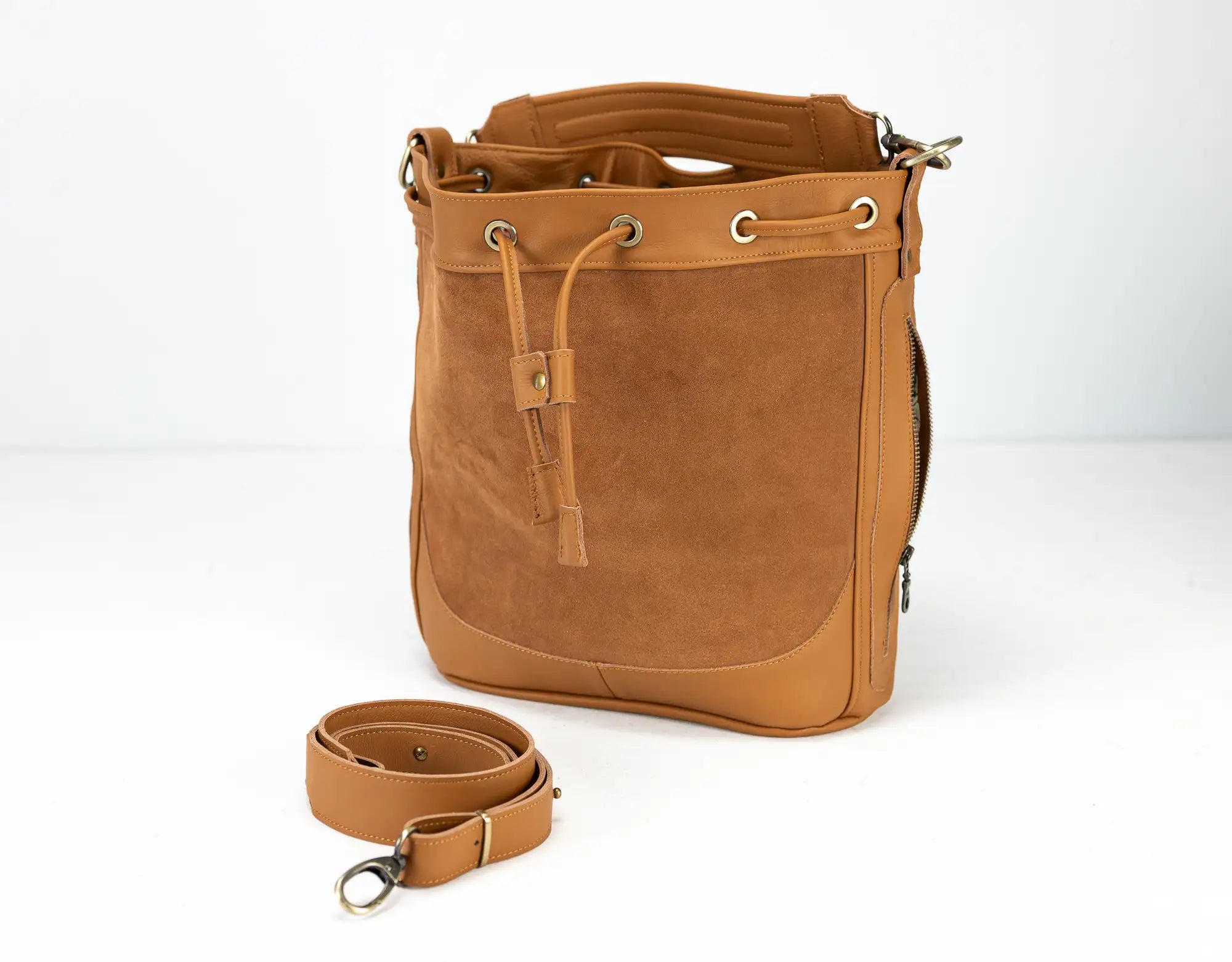 Brown leather bag with strap on a white background
