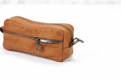 Brown leather dopp kit with zipper on a white background
