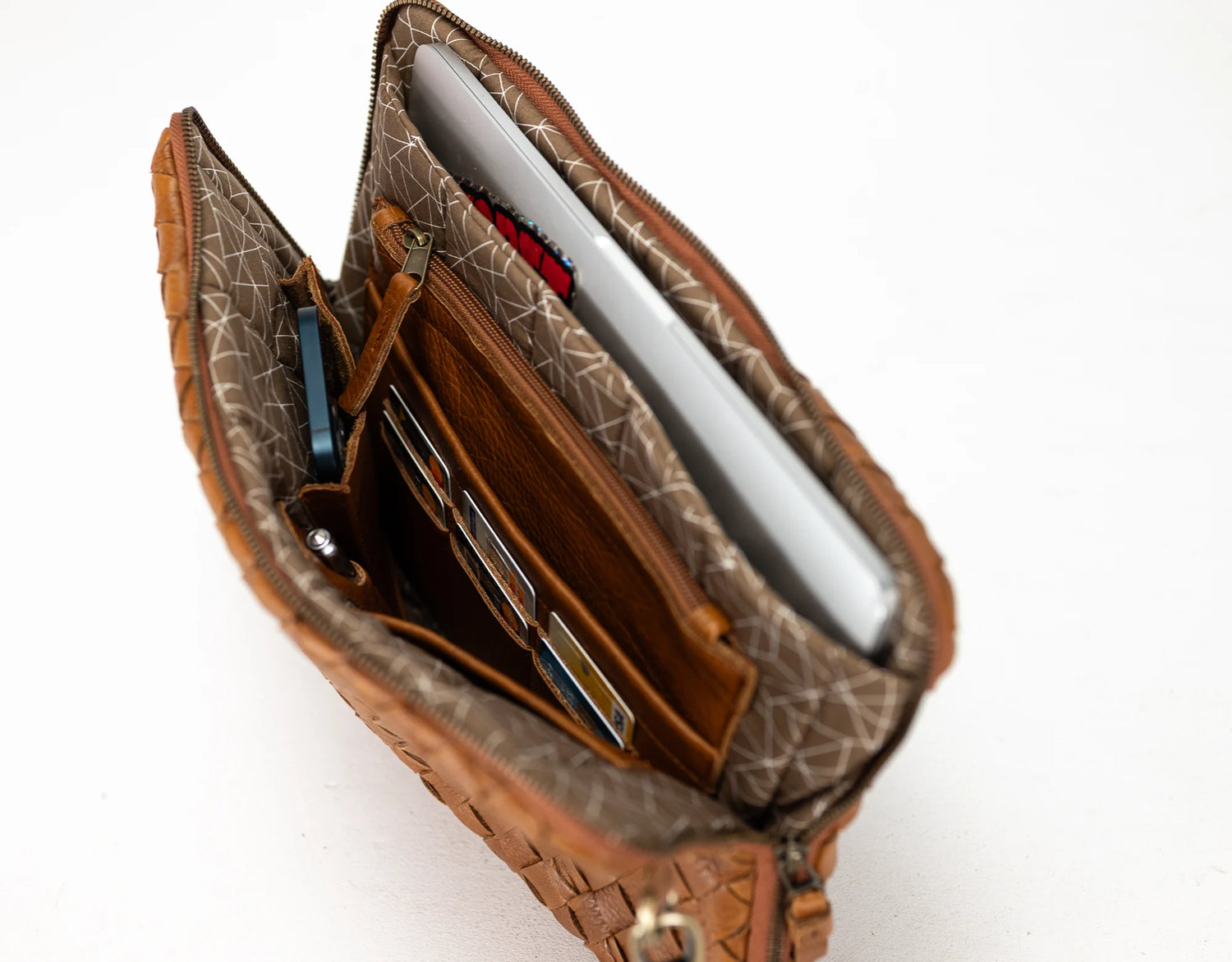 Brown leather clutch with patterned interior on a white background