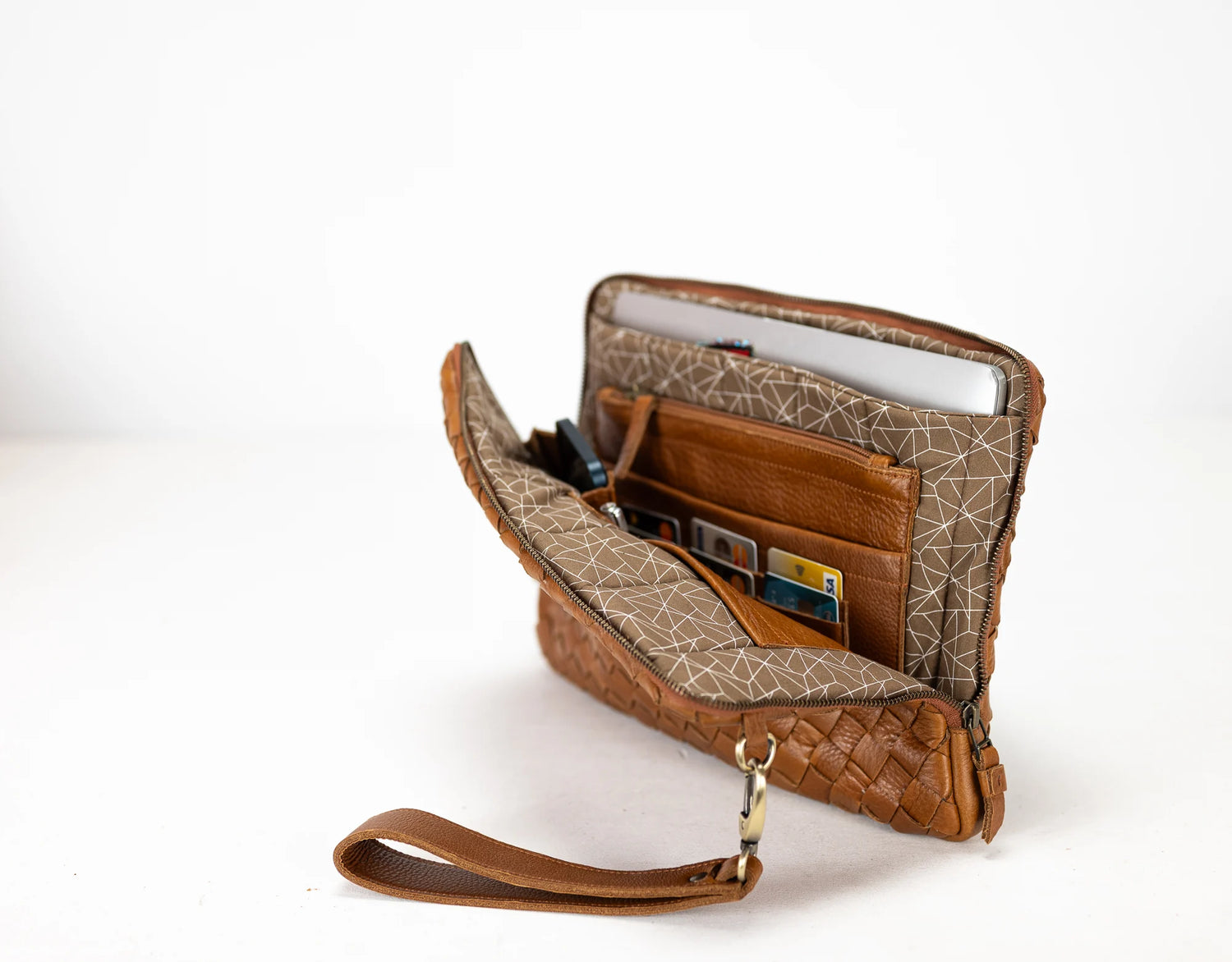 Brown leather clutch with geometric pattern on a white background