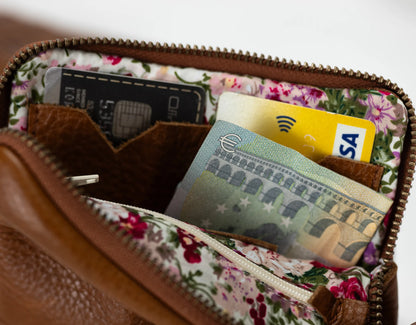 Floral-patterned wallet with cards and a phone inside