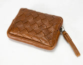 Brown woven leather clutch bag with a strap on a white background