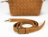 Brown leather strap with gold buckle on a white background