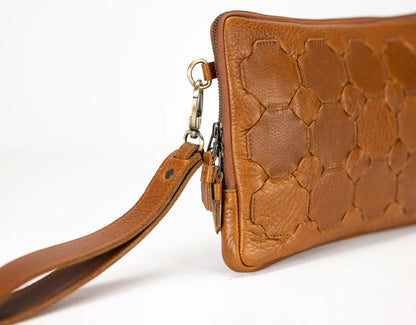 Brown leather handbag with a textured pattern on a white background