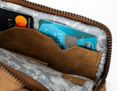 Brown leather wallet with floral pattern holding a card and a Mastercard.