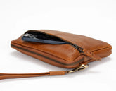 Brown leather clutch with a phone inside on a white background