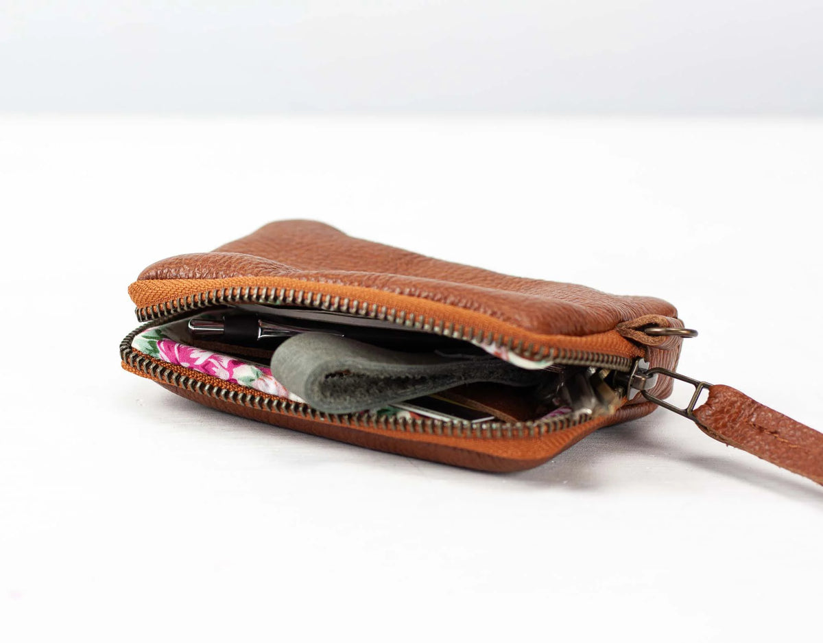 Brown leather pouch with floral lining on a white background#color_brown-pebbled