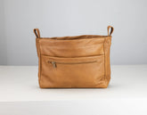 Brown leather bag with a zipper on a white surface and light gray background