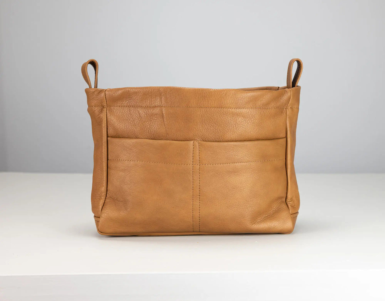 Brown leather bag with handles on a white background