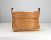Brown leather bag with handles on a white background