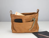 Brown leather bag with compartments on a white surface