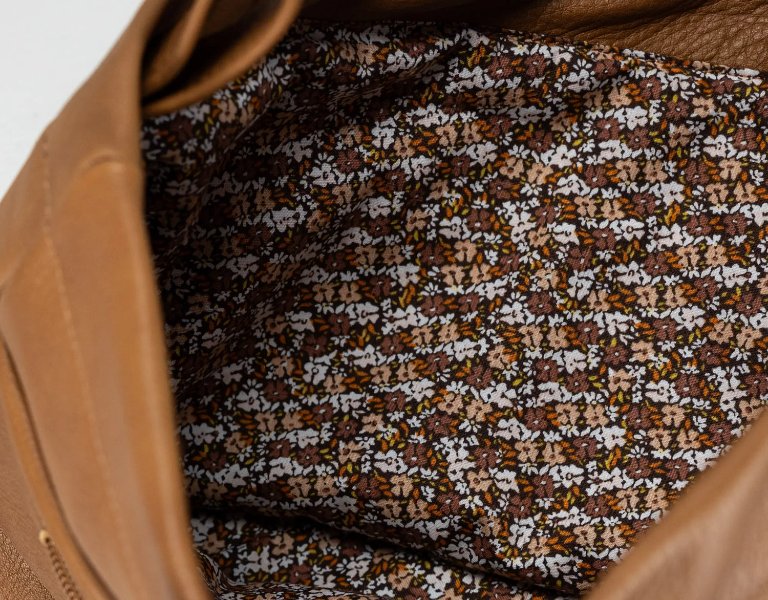 Close-up of a patterned fabric inside a brown leather bag.