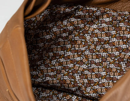 Close-up of a patterned fabric inside a brown leather bag.