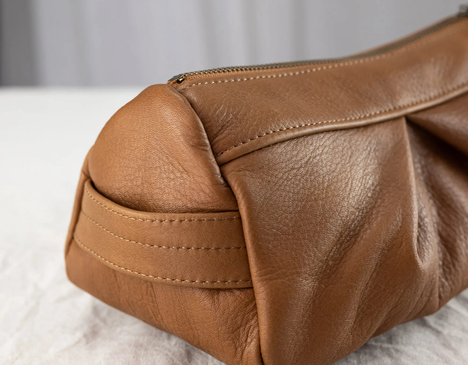 Close-up of a brown leather bag on a light background