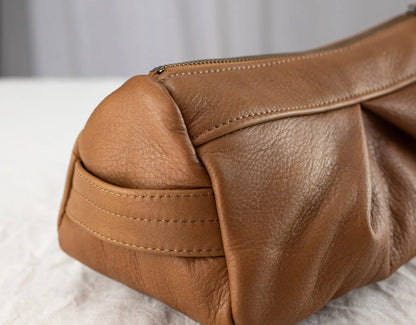 Close-up of a brown leather bag on a light background