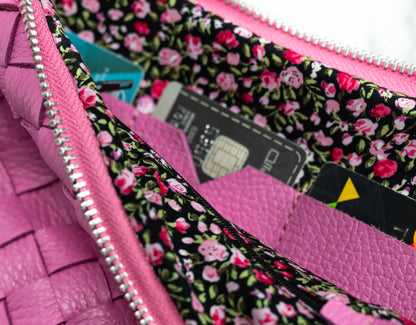 Close-up of a pink wallet with floral lining, showing cards and a pen.
