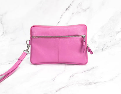 Pink wristlet purse on a white marble background